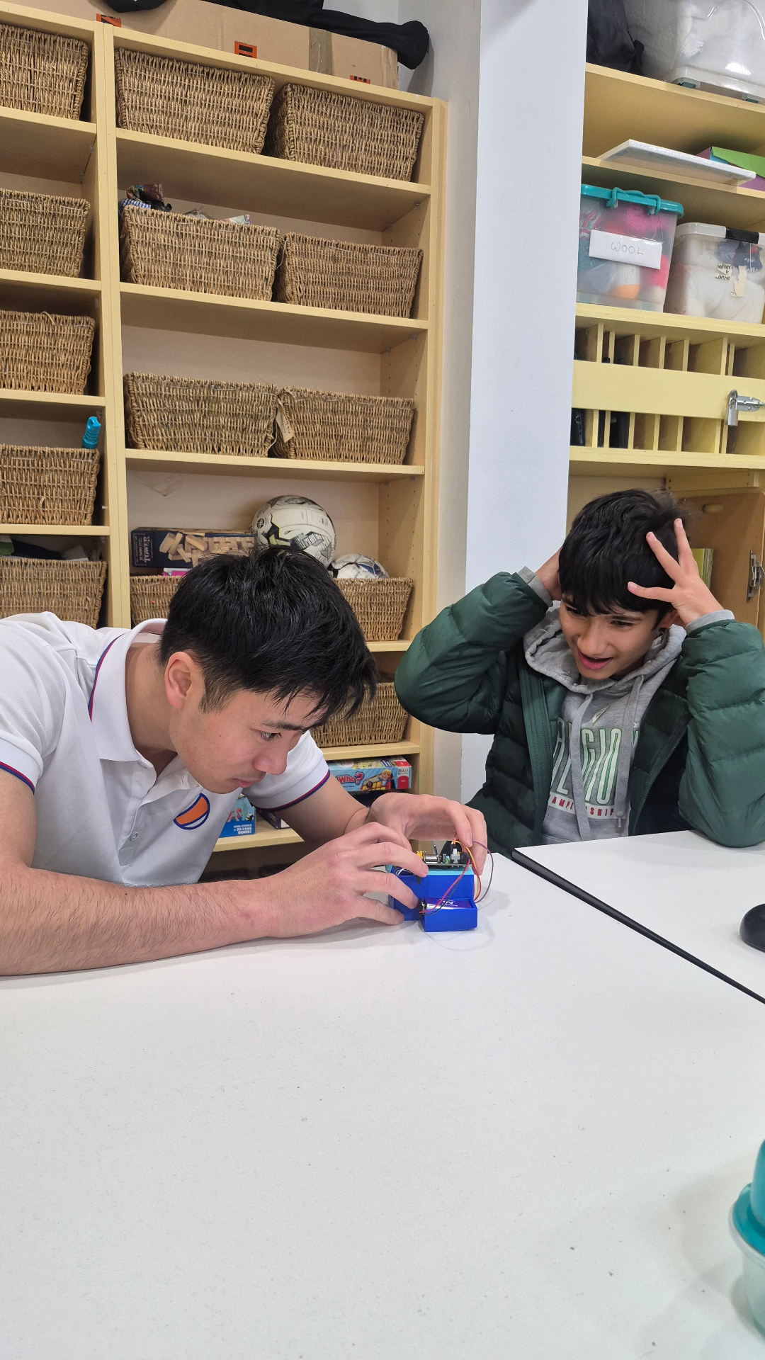 Instructor and excited student working on a robotics build